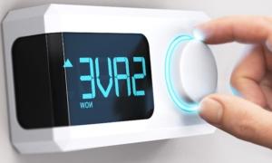 Hand turning a thermostat knob with screen reading "Save Now"